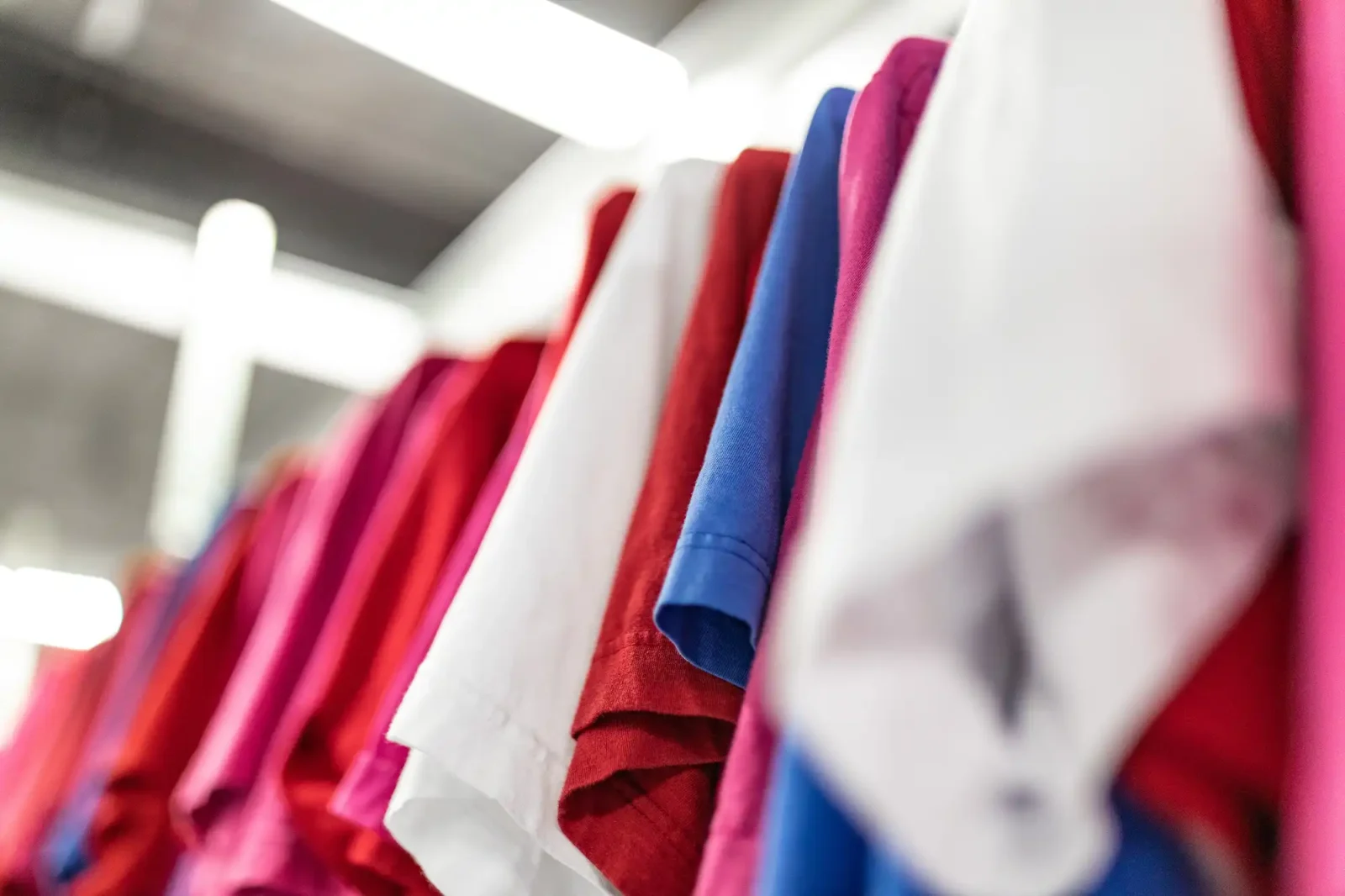 Värikkäitä tekstiilejä ja kankaita rullattuna - sininen, punainen, pinkki ja valkoinen